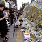 A woman places a flower in memory of a South Korean woman who was stabbed to death at the exit of the Gangham subway station in Seoul on May 21, 2016.