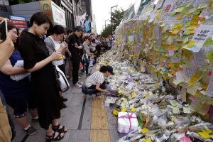 A woman places a flower in memory of a South Korean woman who was stabbed to death at the exit of the Gangham subway station in Seoul on May 21, 2016.