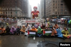 People protest during the 98th Macy's Thanksgiving Day Parade in New York City, U.S., November 28, 2024. REUTERS/Brendan McDermid