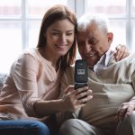 A woman with an older gentleman using a SPC mobile