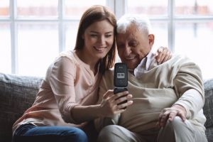 A woman with an older gentleman using a SPC mobile