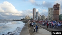 People walk on the seafront boardwalk during a march in protest against the U.S. trade embargo on Cuba, in Havana, Cuba, on Dec. 20, 2024.