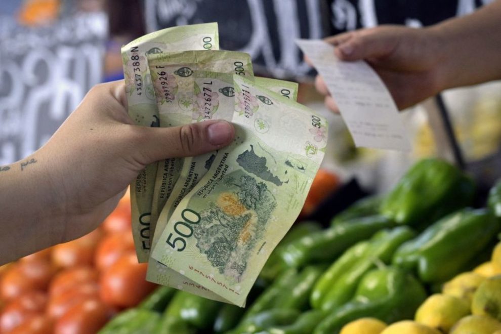 A woman pays for fruits and vegetables at a retail stall in the Mercado Central in Buenos Aires on February 10, 2023, a few days before the announcement of the monthly inflation index. (Photo: JUAN MABROMATA/AFP via Getty Images).