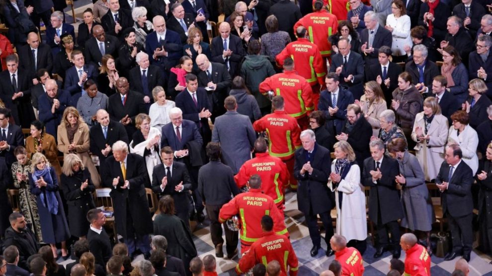 Firefighters, rescuers and builders involved in the restoration walk around the ship in front of attendees, including world leaders and dignitaries.