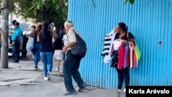 A street vendor in the Historic Center of San Salvador hides two metropolitan agents who prohibit him from approaching with his sale to the tourist squares in the area. [Fotografía: Karla Arévalo / VOA]