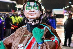 A man wearing a mask of South Korean President Yoon Suk Yeol dances in front of the National Assembly in Seoul, South Korea, on Dec. 4, 2024, after Yoon declared martial law. (AFP)