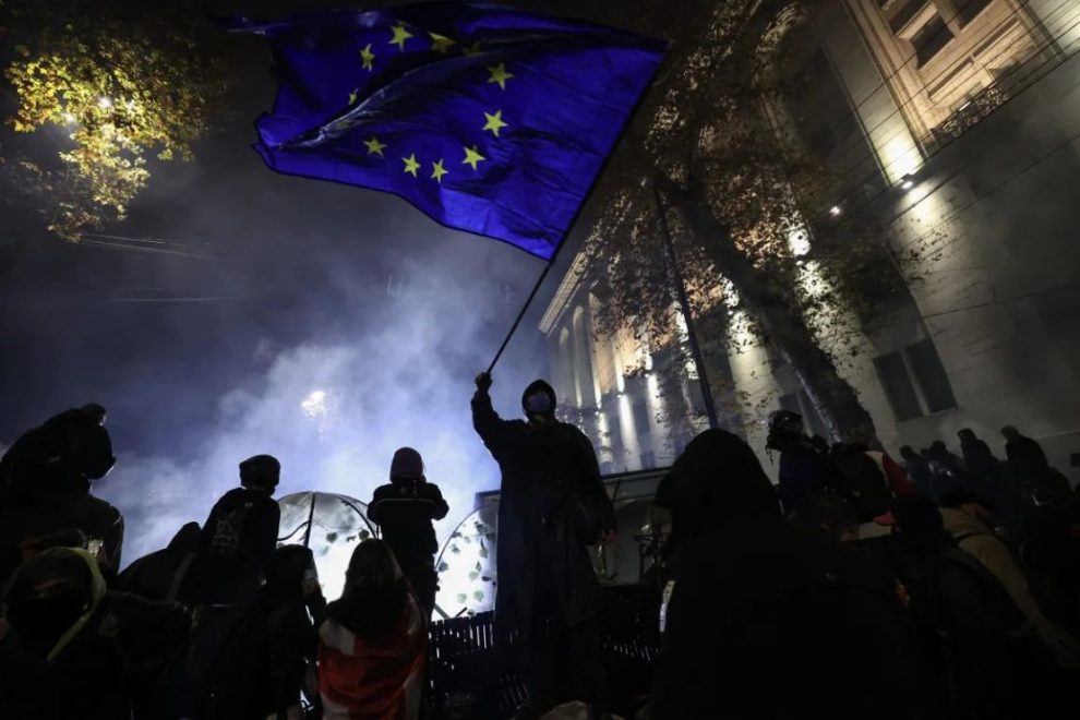 An activist waves a European Union flag as he demonstrates against the government's decision to delay EU accession talks, near the Parliament building in central Tbilisi on November 30, 2024.