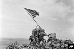 FILE - U.S. Marines of the 28th Regiment, 5th Division, raise an American flag atop Mount Suribachi, Iwo Jima, Japan, Feb. 23, 1945.