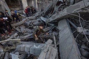 Palestinians inspect rubble in a building after an Israeli attack in the Gaza Strip