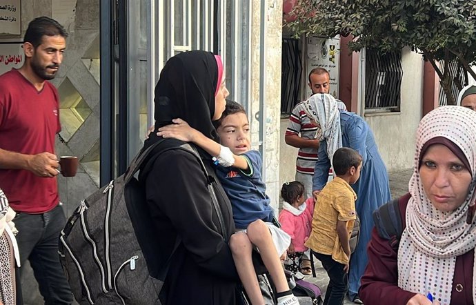 File - A group of Palestinians wait before being transferred to a hospital in Khan Younis.