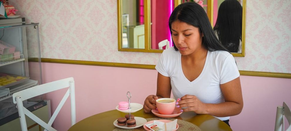 A customer savoring the combination of macarons and coffee at the Zamantha bakery.