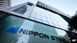 FILE - The Nippon Steel Corporation logo is displayed on a sign outside its headquarters in Tokyo on Nov. 26, 2021.