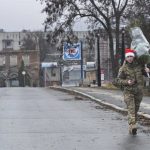 A Ukrainian soldier carries a Christmas tree in Kharkiv