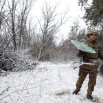 Ukrainian soldier managing a Starlink terminal.