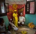 FILE - Marisa Ramírez Gutiérrez, standing in the center, remains motionless on her symbolic throne dressed in the tunic of the "Iyawo"or girlfriend, in Havana, Cuba, on September 11, 2015.