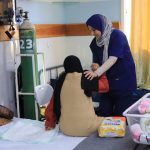 File - An MSF nurse helps a patient at the Emirati Hospital in Rafah.