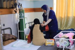 File - An MSF nurse helps a patient at the Emirati Hospital in Rafah.