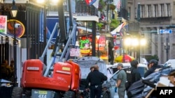 Police investigators surround a white truck that crashed into a work elevator in the French Quarter of New Orleans, Louisiana, on January 1, 2025.