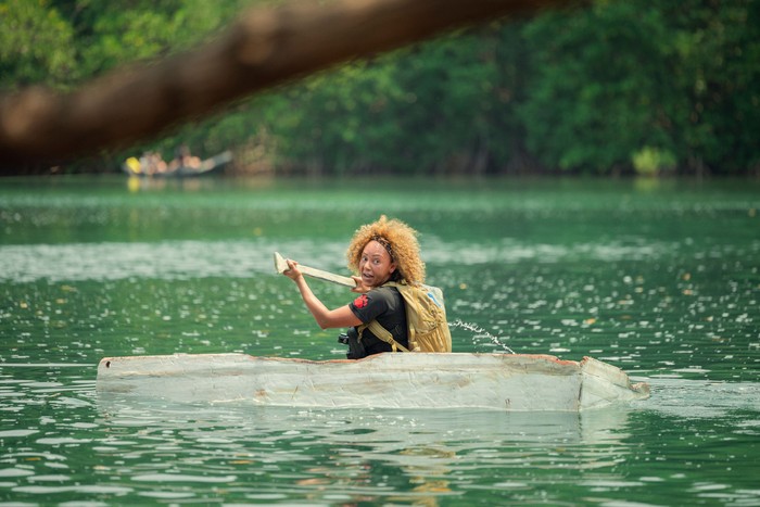 Mel B in a boat, rowing in the middle of a mass of sea.