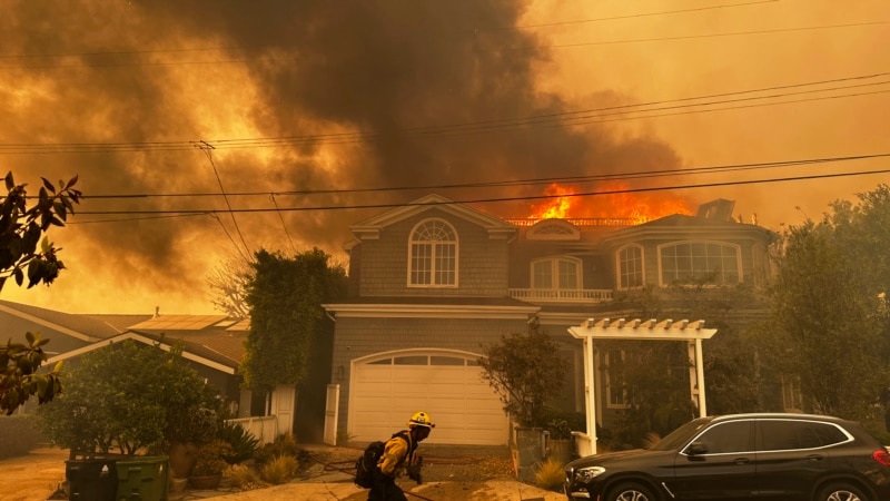 Los Angeles residents flee as wind-fueled fire advances