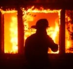 FILE - The silhouette of a firefighter can be seen in front of a burning structure in Los Angeles, on January 7, 2025.