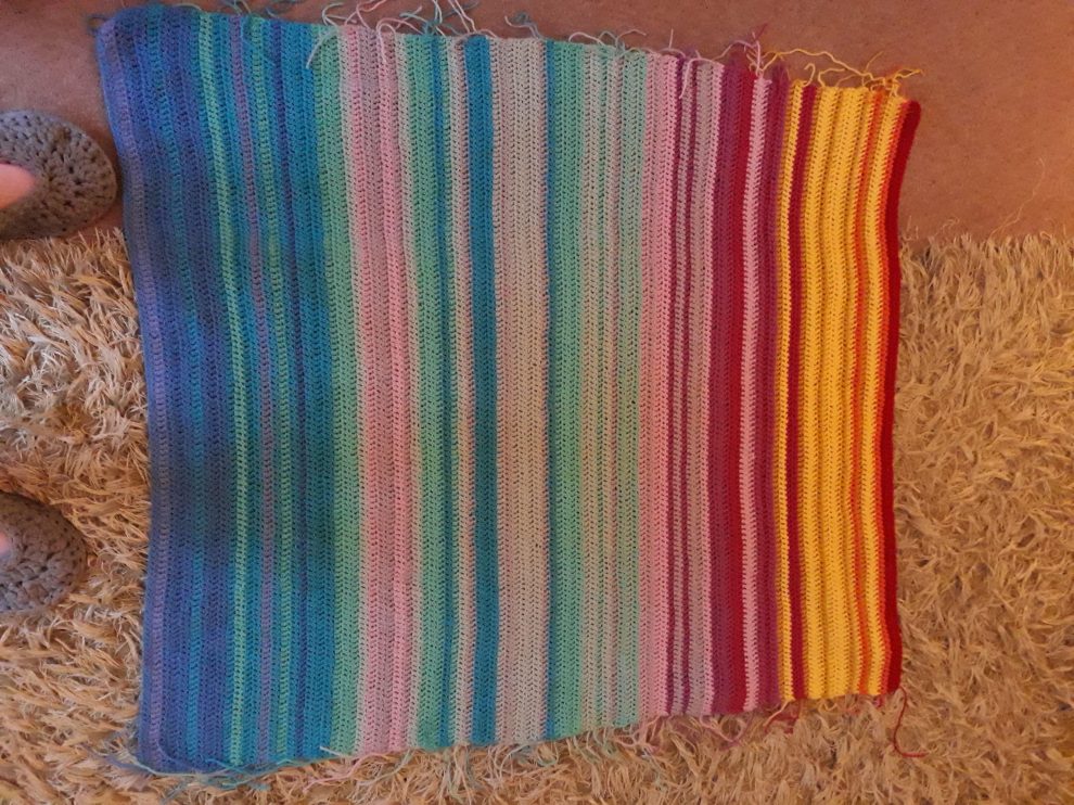 Image of a handwoven blanket with a variety of colors.