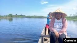 Women navigate a swamp to see where they can throw their cast net, in the town of Cerrito, in the Colombian Caribbean, December 2024.